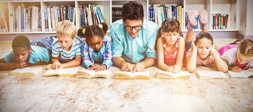 Home teacher and kids reading book in library